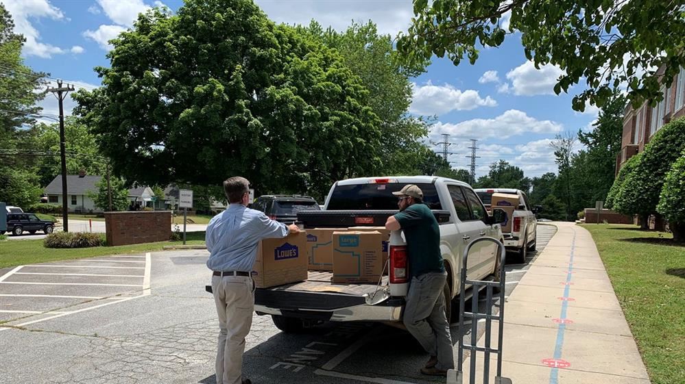 People standing by truck with boxes.